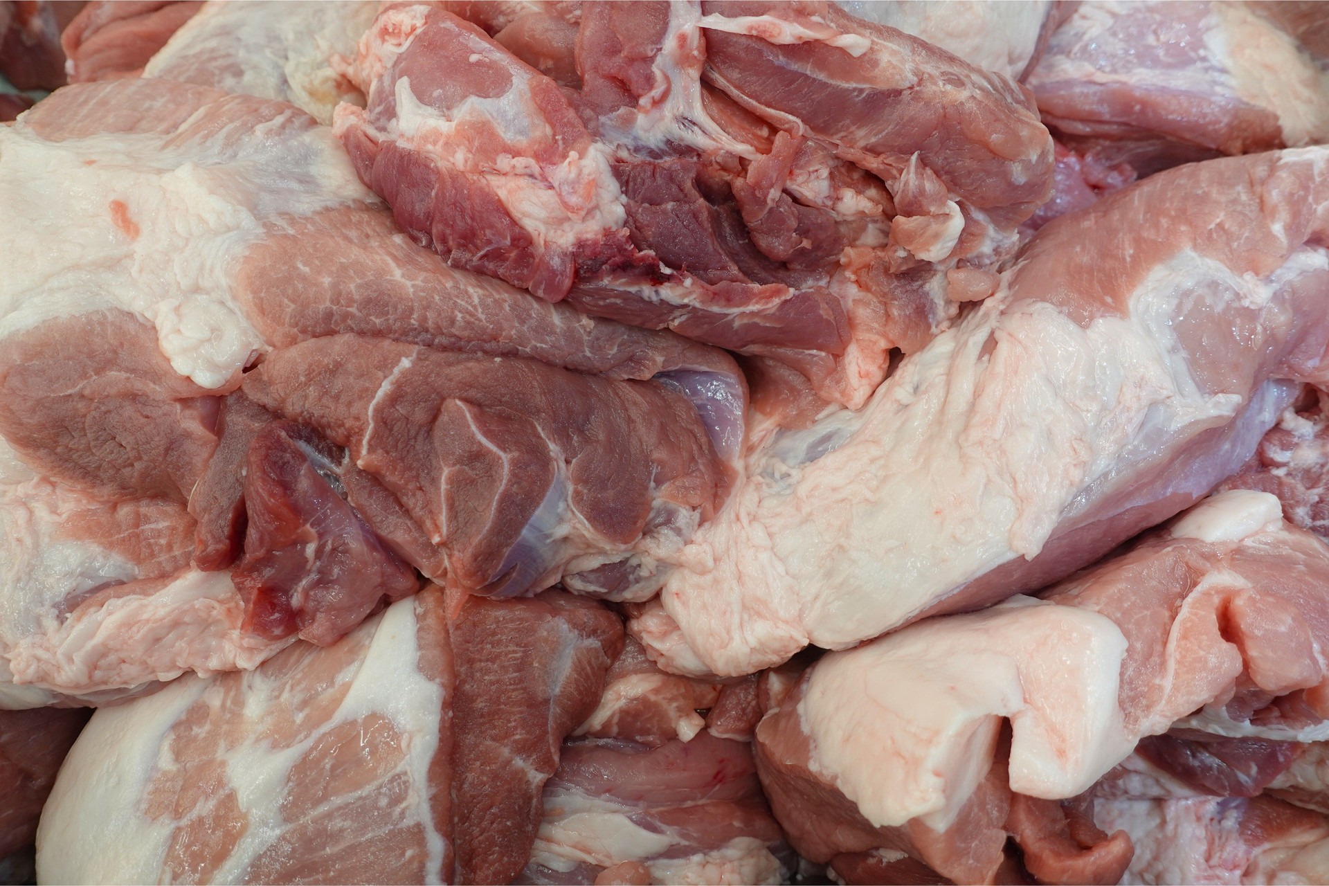 Close-up of Fresh Raw Pork Meat Cuts Piled in a Butcher Shop. Stock Photo