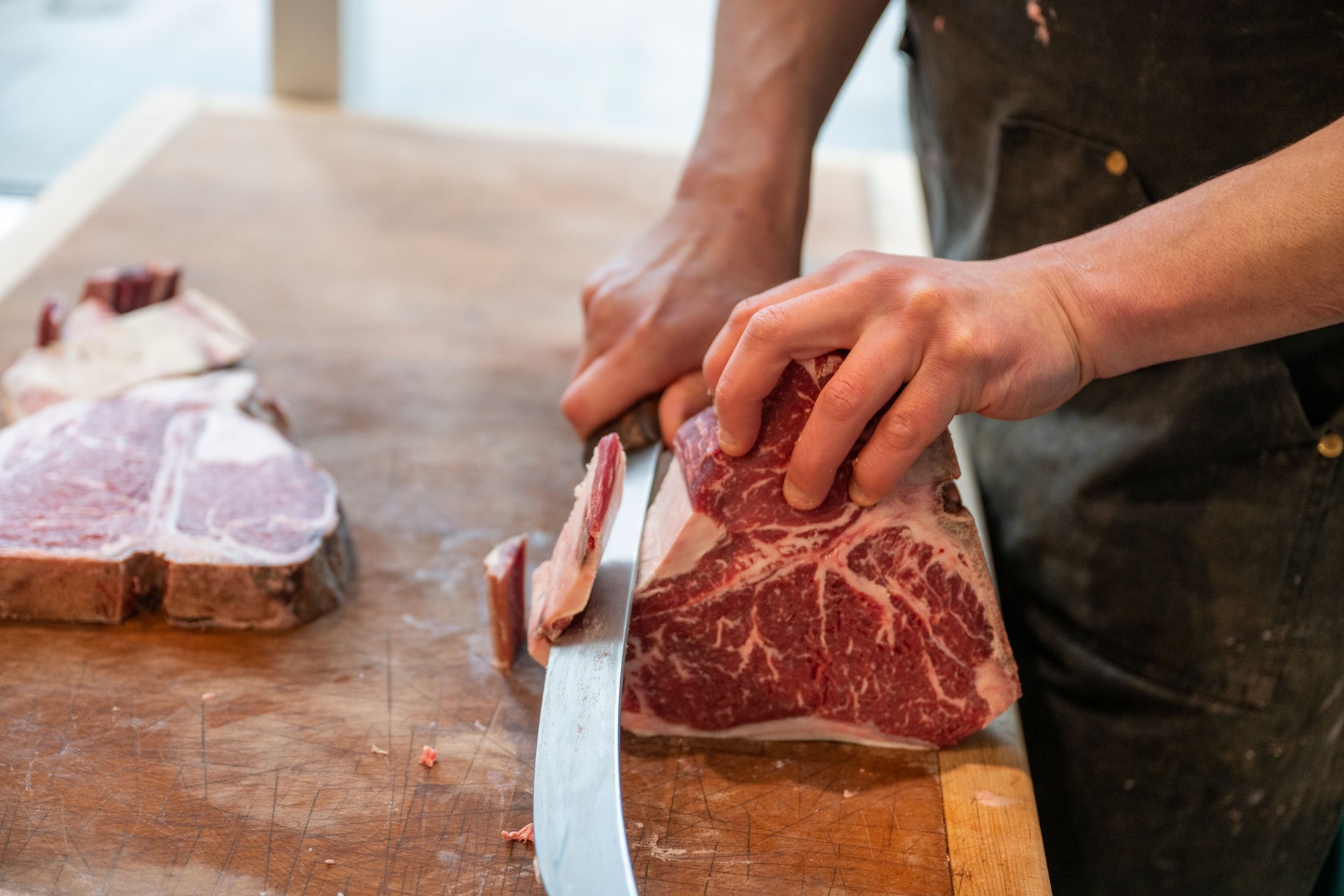 Close-up of butcher slicing raw meat